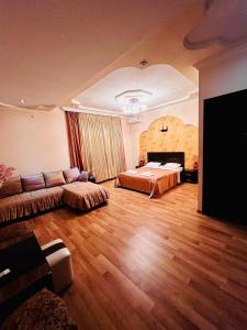 ein großes Wohnzimmer mit einem Bett und einem Sofa in der Unterkunft Lux Palace Hotel in Kutaissi