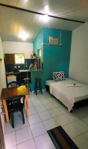 um quarto com uma cama, uma mesa e uma sala de jantar em Eco chalés 1 e 2 em Cabo de Santo Agostinho