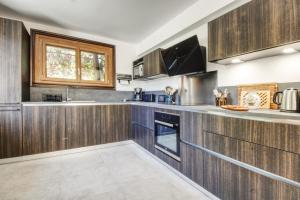a kitchen with wooden cabinets and a window at Chalet Sol in Chamonix