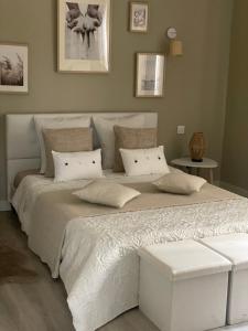 sypialnia z dużym łóżkiem z białą pościelą i poduszkami w obiekcie Chez Flo w Awinionie