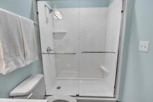 a shower with a glass door in a bathroom at Hoppy Hideaway: Coastal Loft with a Brewery Twist in Myrtle Beach