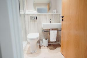 a bathroom with a white toilet and a sink at The Dunes in Tenby +32 photos