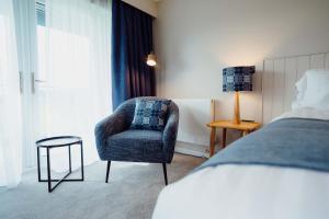 a bedroom with a chair and a bed at The Dunes in Tenby