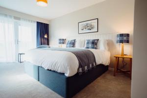 a bedroom with a large bed and a window at The Dunes in Tenby
