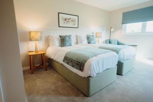 two beds in a room with two lamps at The Dunes in Tenby