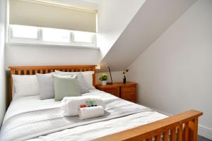 a bedroom with a large white bed with white pillows at Spacious 2 bedroom apartment in the heart mumbles in The Mumbles