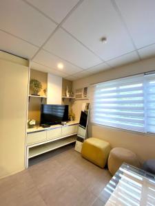 een woonkamer met een tv en een raam bij Smart Condominium Official in Cagayan de Oro