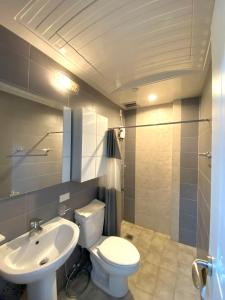 Łazienka z białą toaletą i umywalką w obiekcie Smart Condominium Official w mieście Cagayan de Oro