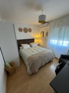 a bedroom with a bed and a table and a chair at Harmony room málaga piso compartido in Málaga