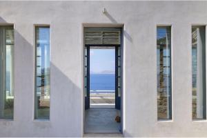 een deur naar een huis met uitzicht op de oceaan bij Luxurious Mykonos Villa 7 Bedrooms Villa Melianthe Private Infinity Pool and Astounding Sunset Sea Views Agios Ioannis in Dexamenes