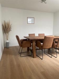een eetkamer met een houten tafel en stoelen bij Ingerichte woning met tuin in Leuven
