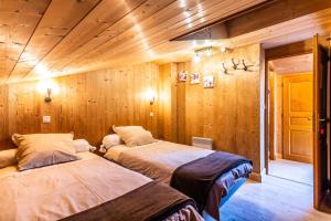 モルジヌにあるGRANGE 3のベッド2台 木製の壁の部屋