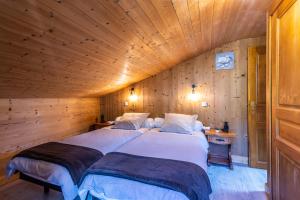 モルジヌにあるGRANGE 3のベッド2台 木製の壁の部屋