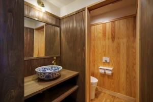 a bathroom with a bowl on a counter and a toilet at ゲストハウス小布施 in Obuse