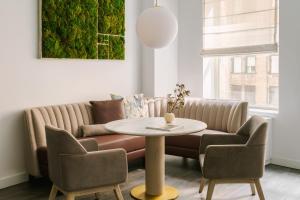 a living room with a couch and a table and chairs at Sonder City Hall Park in New York