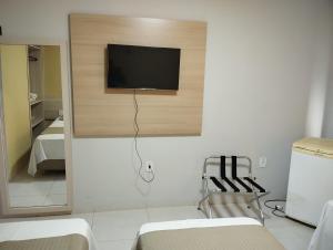 Una habitación con un televisor de pantalla plana en una pared. en Gurgueia Park Hotel, en Cristino Castro