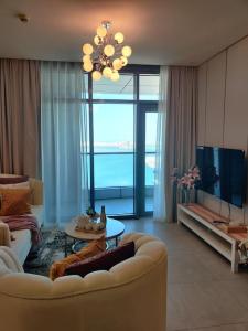 Apartment number 365 Era View في المنامة: غرفة معيشة بها أريكة بيضاء وتلفزيون