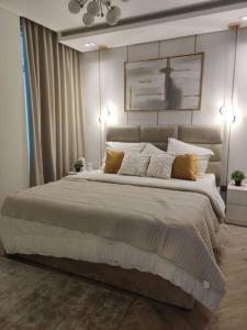 una camera da letto con un grande letto con cuscini di Apartment number 365 Era View a Manama