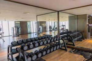 a gym with rows of dumbbells and mirrors at Apartment number 365 Era View in Manama