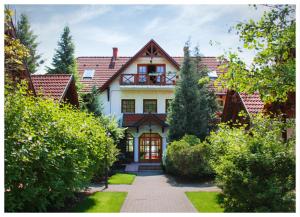 una gran casa blanca con un camino delante en Hotel Sunshine Balatonlelle, en Balatonlelle