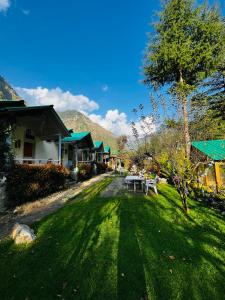 a yard with a picnic table and some buildings at The Stream Kasol in Kasol
