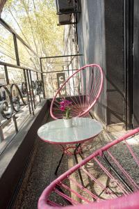 a pink chair and a table on a balcony at PH Palermo Hostel in Buenos Aires