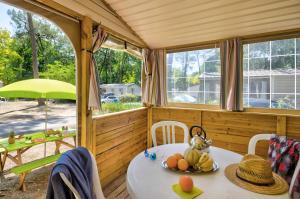 ein Zimmer mit einem Tisch und Stühlen in einem Haus in der Unterkunft Flower Camping Les Biches in Saint-Hilaire-de-Riez