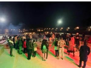 eine Gruppe von Menschen, die nachts am Strand spazieren in der Unterkunft Griat sandy desert camp jaisalmer in Jaisalmer