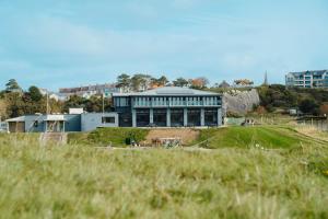 a large building on top of a hill with a field at The Dunes in Tenby