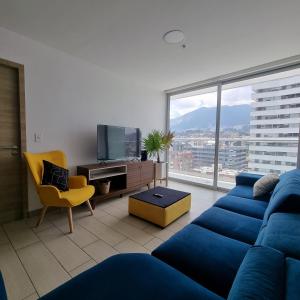 sala de estar con sofá azul y ventana grande en Suite Martina 2 Personas Quito, en Quito