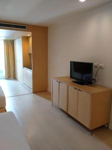 a living room with a flat screen tv on a cabinet at The Tivoli Hotel in Bangkok