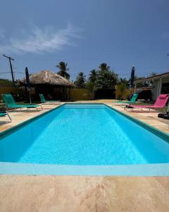 a blue swimming pool with chairs and a house at Pousada Reloday in Salvaterra