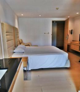 um quarto com uma grande cama branca num quarto em The Tivoli Hotel em Banguecoque