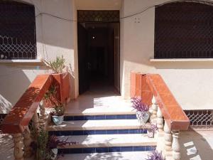 un bâtiment avec des escaliers et une porte avec des plantes en pot dans l'établissement Rez-de-chaussée villa touta, à Béni Mellal