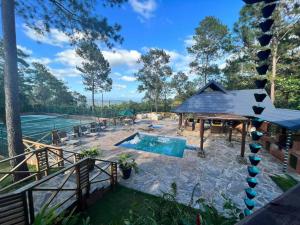 un patio trasero con piscina y pista de tenis en Villa las Tres Marias 24 personas chef incluido en Jarabacoa