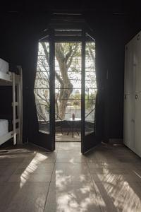 ein Schlafzimmer mit einer Tür, die zu einem Baum führt in der Unterkunft PH Palermo Hostel in Buenos Aires