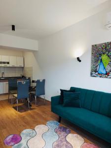 a living room with a green couch and a kitchen at Relax in Apartment Stela in Skopje