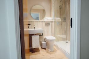 a bathroom with a sink and a toilet and a mirror at The Dunes in Tenby