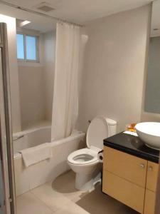 uma casa de banho com um WC branco e um lavatório. em The Tivoli Hotel em Banguecoque