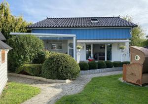 una casa con una casa azul con arbustos en Haus Sansibar Niendorf, en Timmendorfer Strand