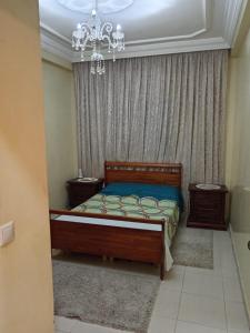 sypialnia z łóżkiem i żyrandolem w obiekcie Appartement la vallée w mieście Safi