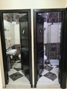 een badkamer met 2 glazen deuren en een wastafel bij Appartement la vallée in Safi