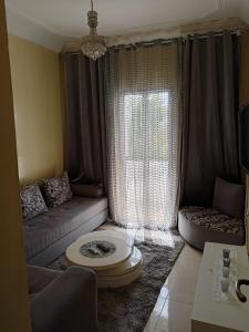een woonkamer met een bank en een raam bij Appartement la vallée in Safi