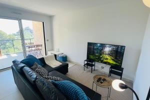 sala de estar con sofá y TV de pantalla plana en A dream on the Cote d'Azur, en Èze