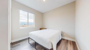 un dormitorio con una cama y una ventana en Scenic Mountain Views at Olympia Way-Unit A, en Kalispell