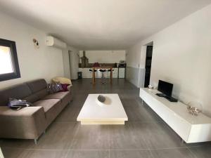 una sala de estar con un sofá y una mesa en Bas de villa - Canella, en Sari Solenzara