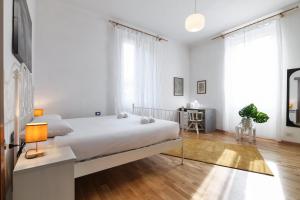een witte slaapkamer met een bed en een bureau bij PrimoPiano - Tibaldi in Milaan