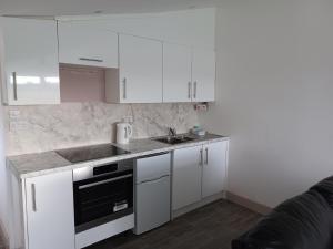 eine weiße Küche mit Spüle und Herd in der Unterkunft Redhouse Farm Cottage the most dog friendly place Ive ever stayed in Withernsea + 3 Fotos