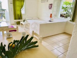 Optasia Apartments في خيرسونيسوس: غرفة بسرير وطاولة مع نبات