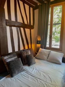 a bedroom with a bed with pillows and a window at Studio Les Poutres centre-ville Rouen in Rouen
